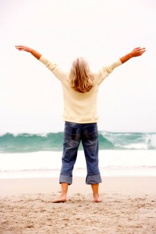 Senior Woman With Arms Outstretched On Winter Beach